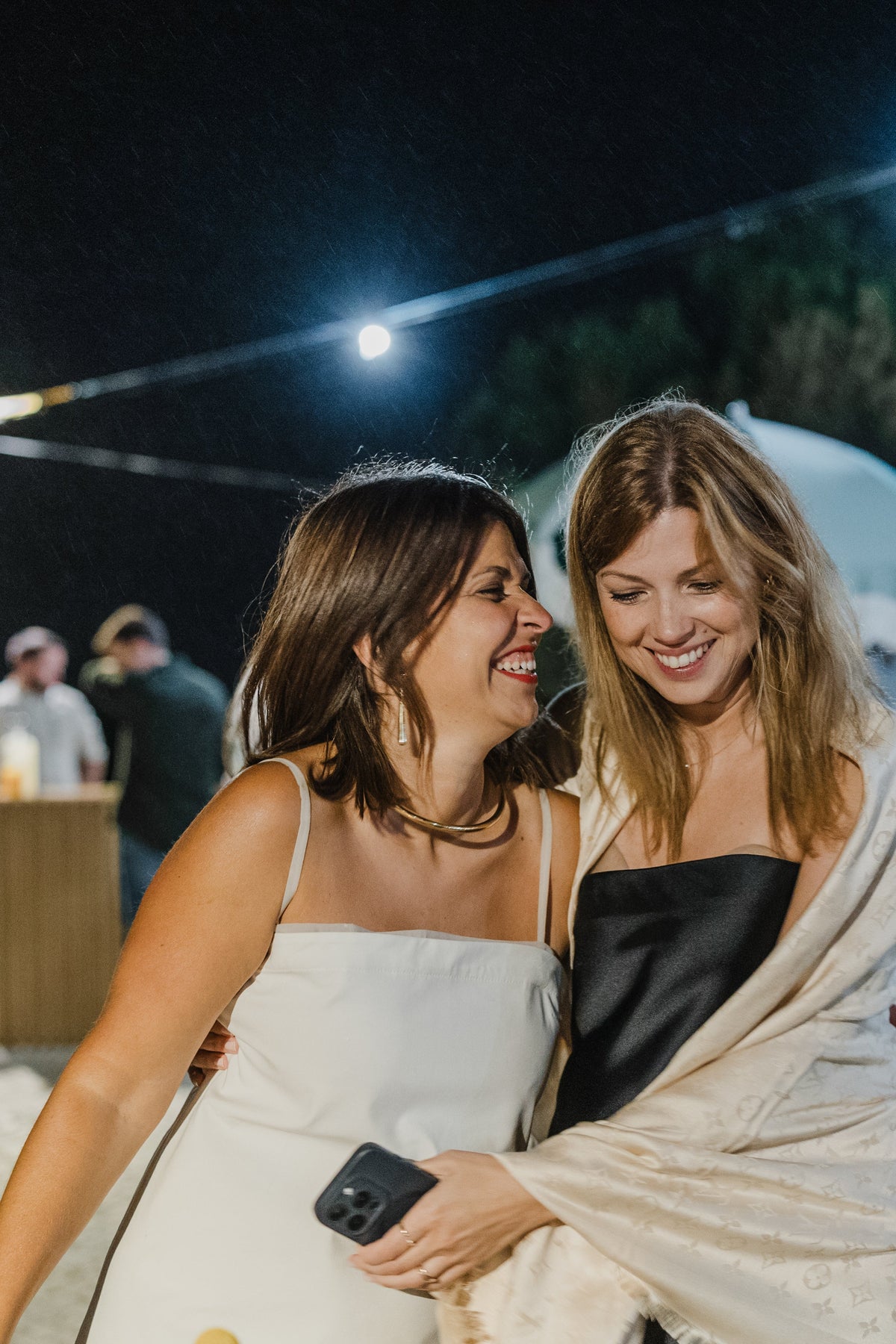 Stylish bridesmaid gift ideas showcase a joyful moment between friends at an elegant night celebration.