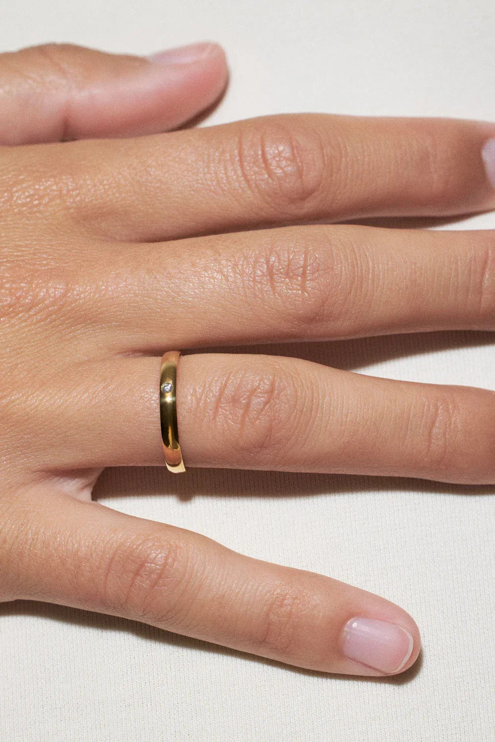 how to choose wedding rings: close-up of a gold wedding ring on a hand
