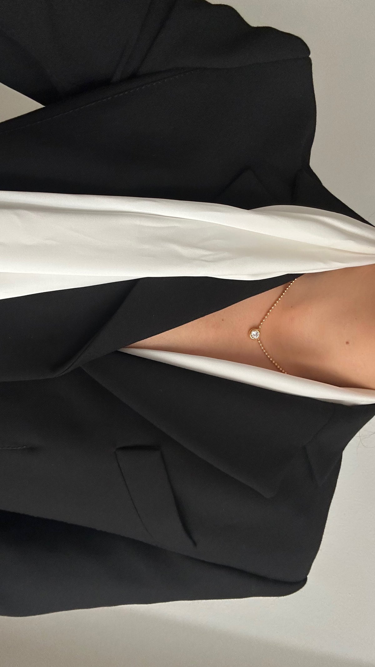 CINCO elegant necklace with a diamond pendant worn with a white scarf and black blazer, detail view