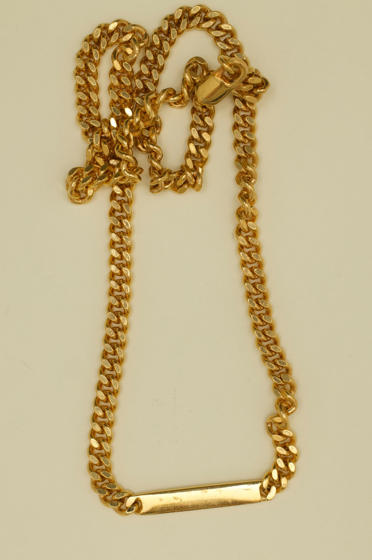 Gold chain necklace on a beige background