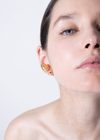 Gold plated vintage piercing showcased on a model's ear, highlighting its elegant design and shine.