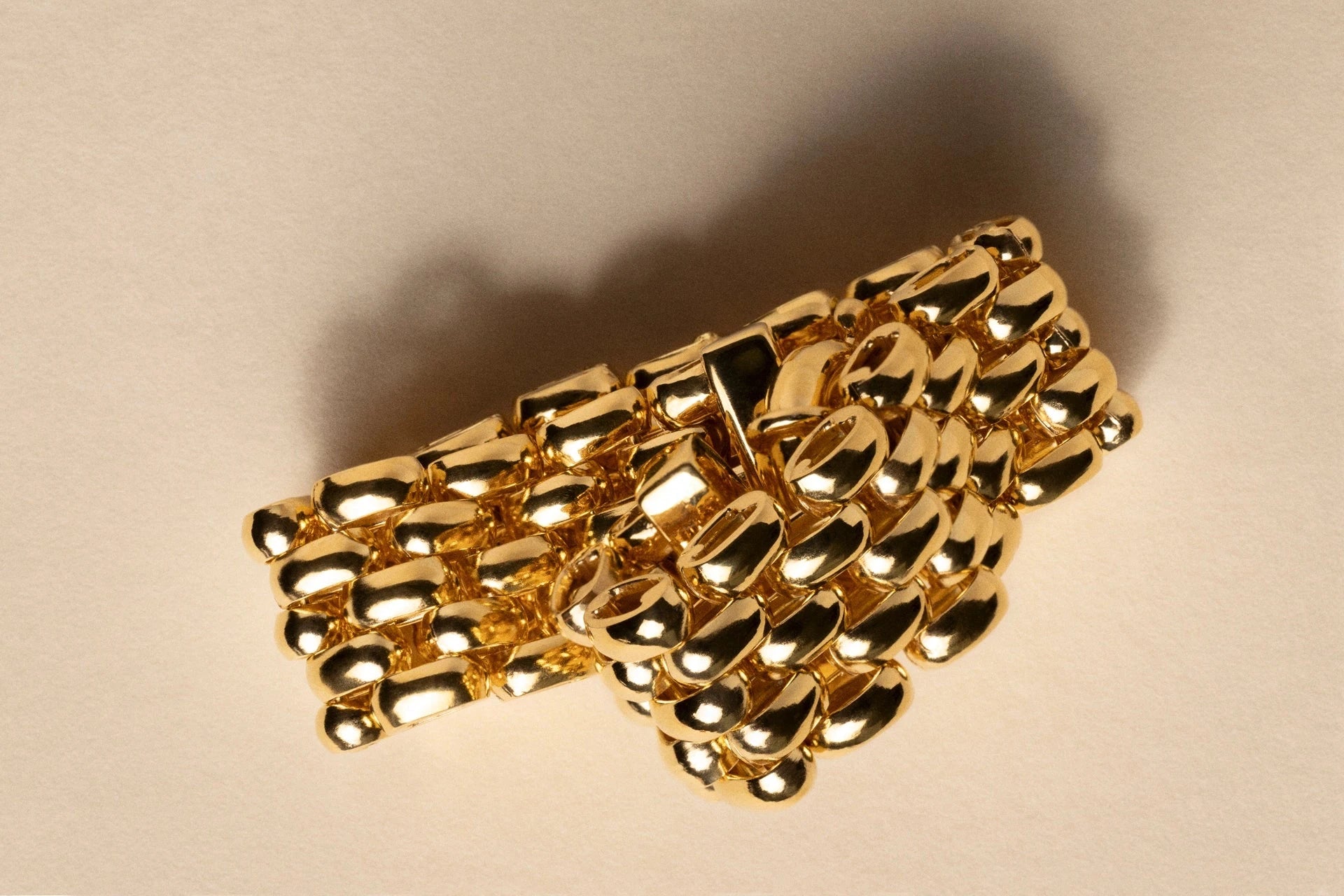 Gold chain bracelet on a beige background