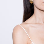 model wearing gala earrings in gold 