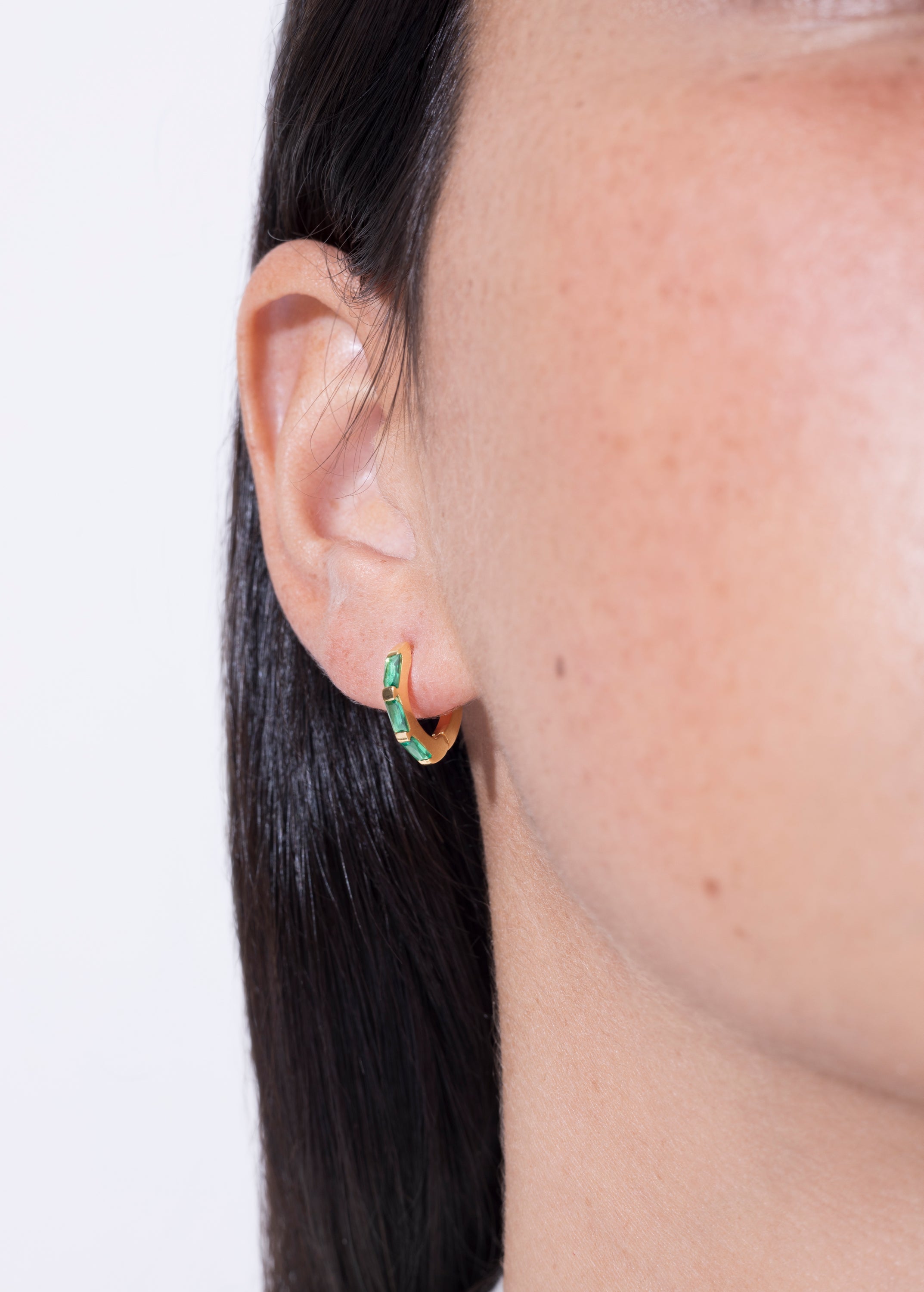 model wearing norma earrings emerald in gold